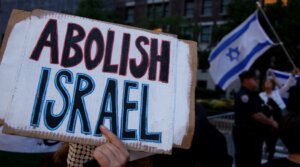 A pro-Palestinian activist holds a sign during the “Autonomous Noise Demonstration for Gaza” near supporters of Israel holding Israeli flagsoutside the hotel of Israel’s Prime Minister Benjamin Netanyahu in New York City on September 25, 2025. (Leonardo MUNOZ / AFP)