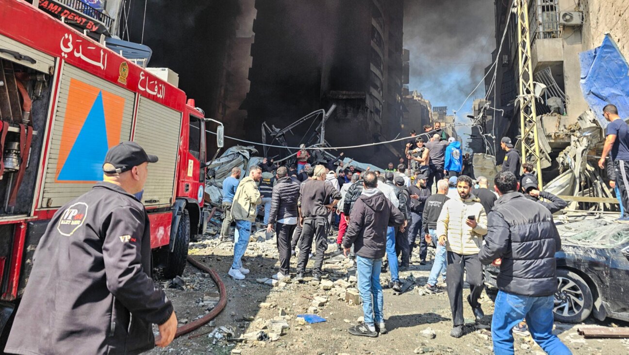 First responders and residents stand amid rubble at the site of an Israeli airstrike in Beirut’s Corniche al-Mazraa neighborhood on April 8, 2026. 