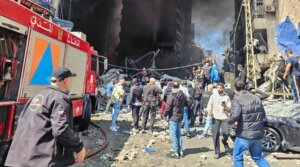 First responders and residents stand amid rubble at the site of an Israeli airstrike in Beirut’s Corniche al-Mazraa neighborhood on April 8, 2026. 
