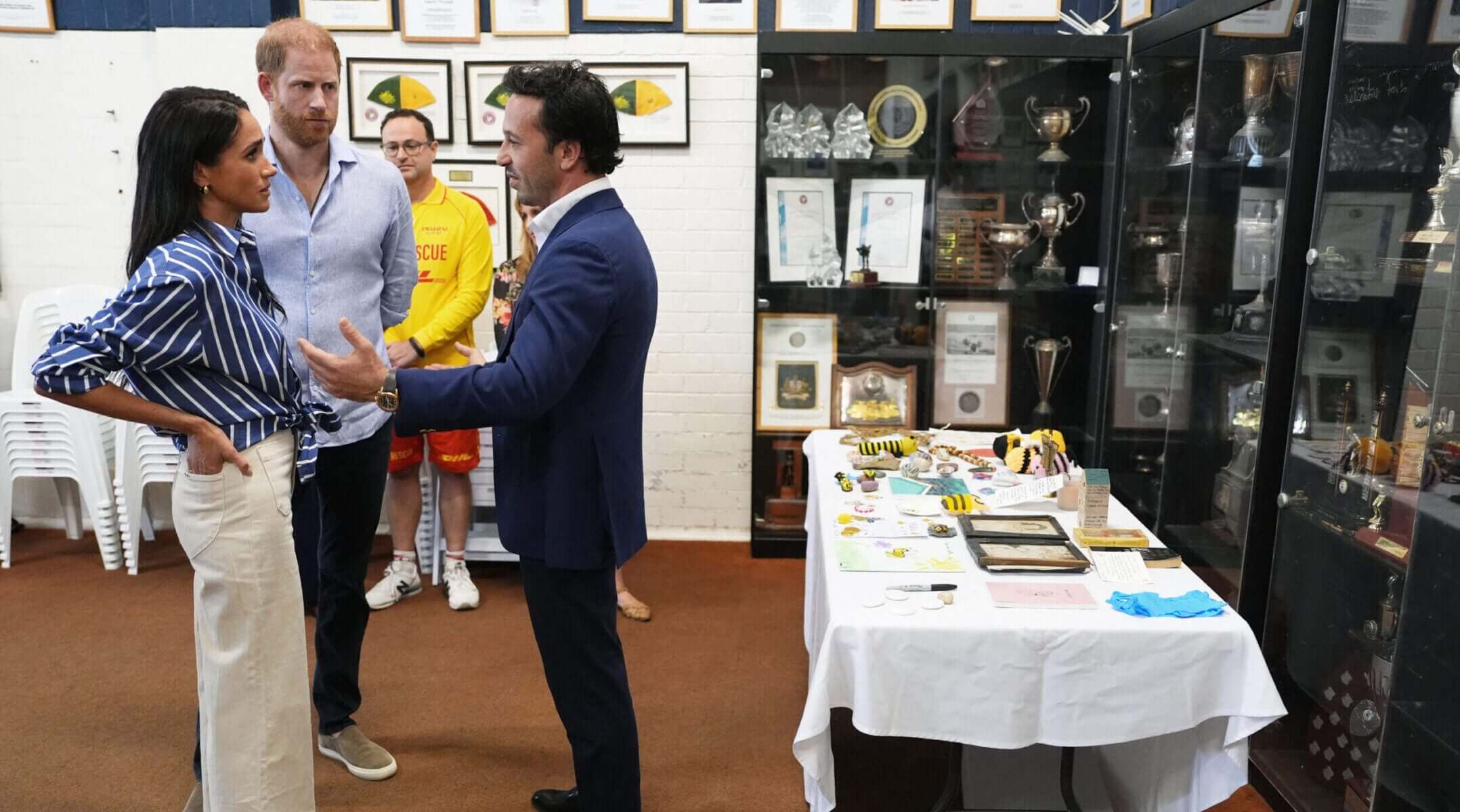 Britain’s Prince Harry, and his wife Meghan Markle speak with Elon Zizer, Bondi Beach Hanukkah attack survivor, during a meeting at the Bondi Surf Bathers’ Life Saving Club in Sydney, April 17, 2026. Artifacts from the aftermath of the shooting lie on the table behind Zizer.