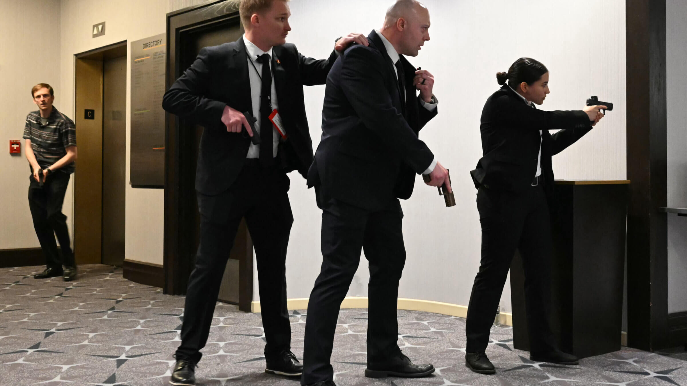 Agents draw their guns after loud bangs were heard during the White House Correspondents' dinner 