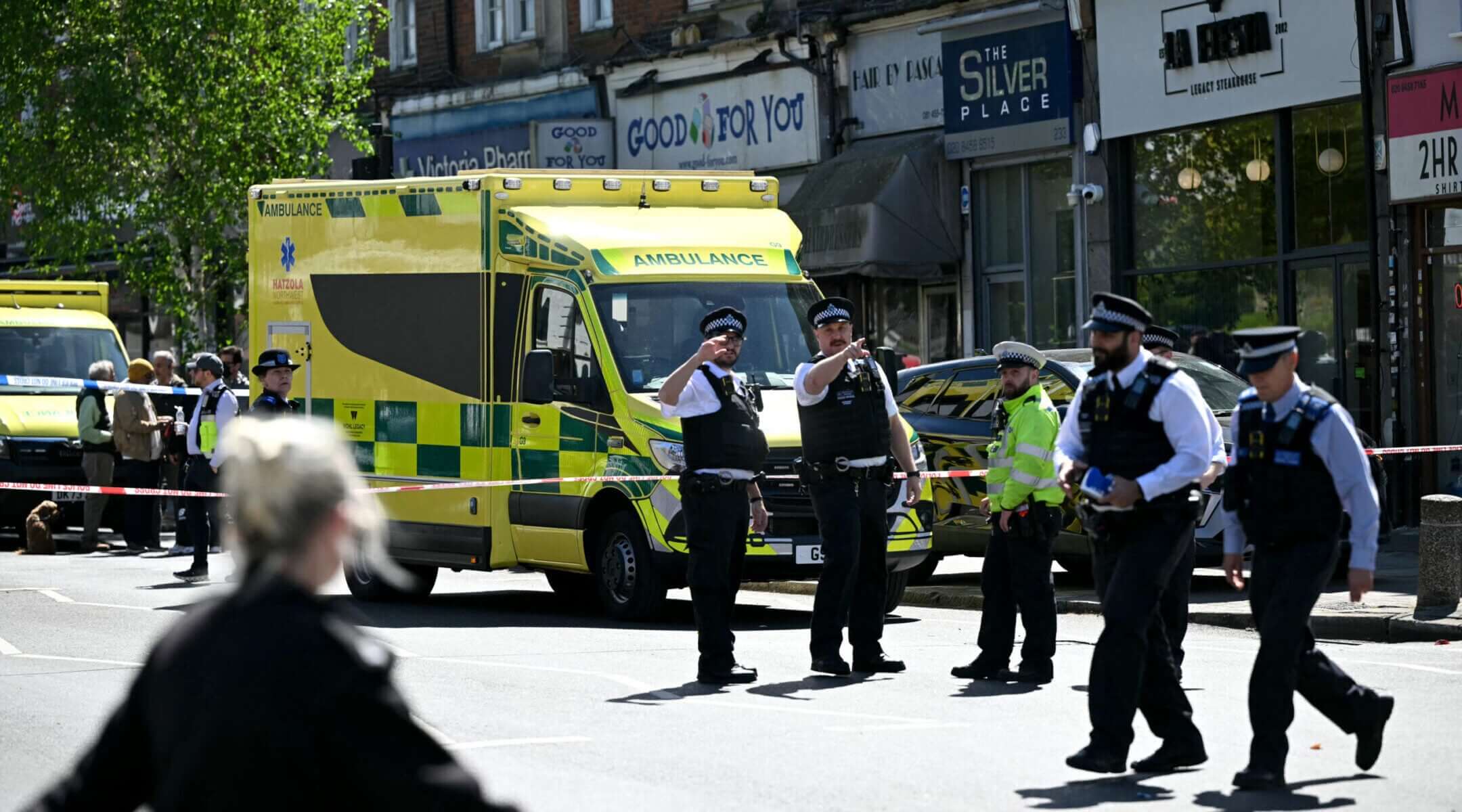 Police walk within a cordoned off area in the Golders Green neighborhood of north London, on April 29, 2026, after two people were stabbed, and a suspect arrested.