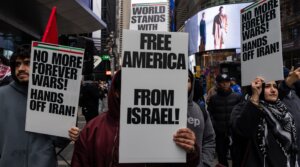 People take part in a protest and march gathering at Times Square to oppose the joint U.S.-Israel war on Iran in New York City on March 13, 2026. (Mostafa Bassim/Anadolu via Getty Images)