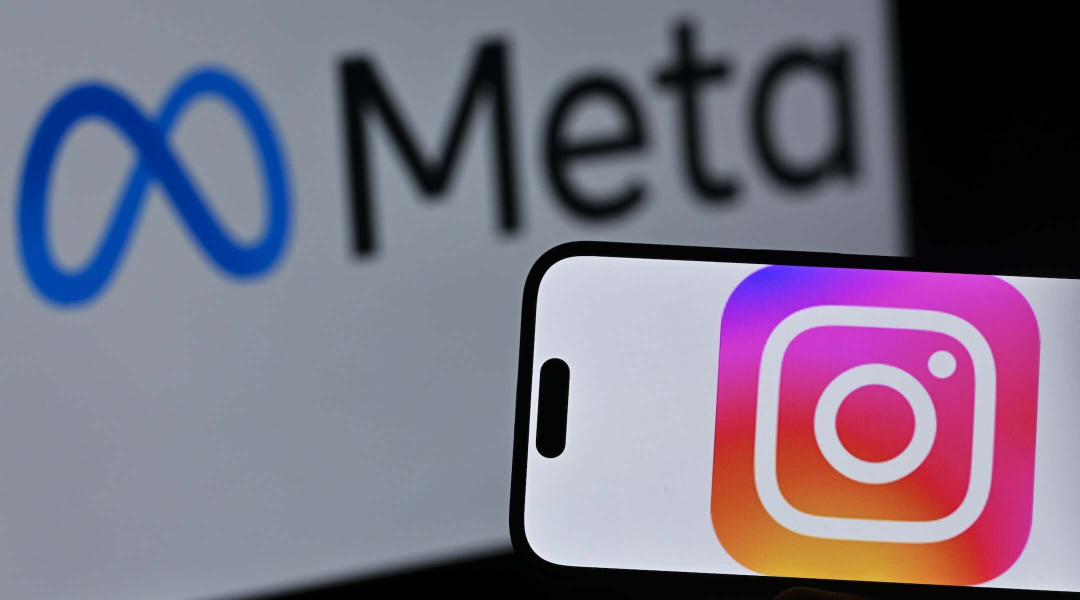 The Instagram logo is displayed on a mobile phone screen in front of a computer screen displaying Meta logo on April 10, 2026.