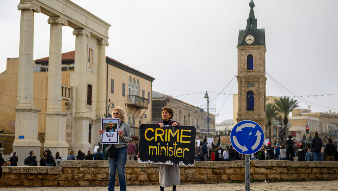 A woman holds a sign reading "crime minister" at a protest against the government's handling of violence against Israeli Arabs on Feb. 10 in the Jaffa area of Tel Aviv, Israel.