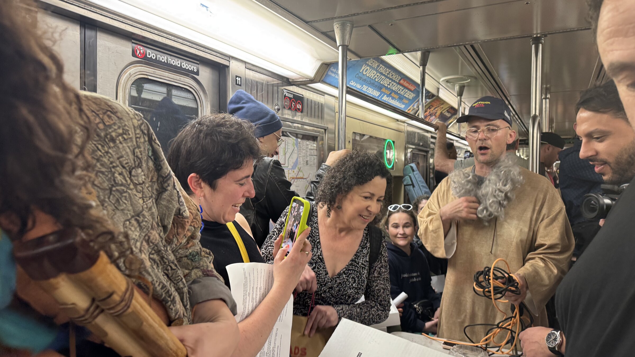 Rapper Kosha Dillz (right) leads the subway Seder. 