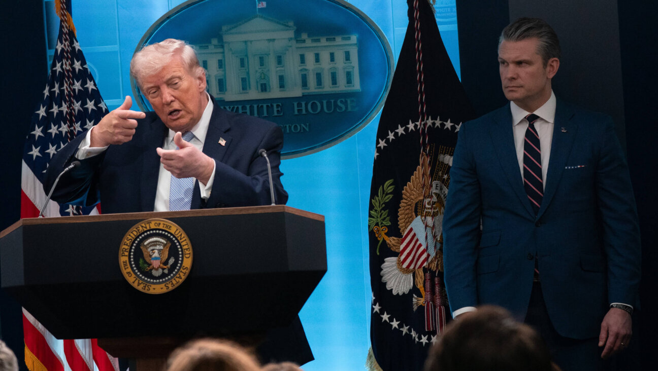 President Donald Trump mimics firing a rifle while speaking to reporters at a briefing on Monday, April 6, at the White House in Washington, D.C.