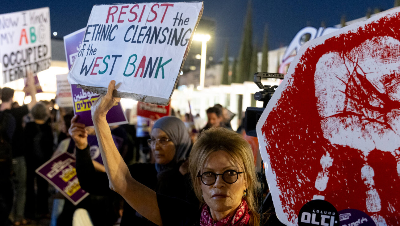Protesters hold signs during a Tel Aviv rally against settler violence in the West Bank on April 16.