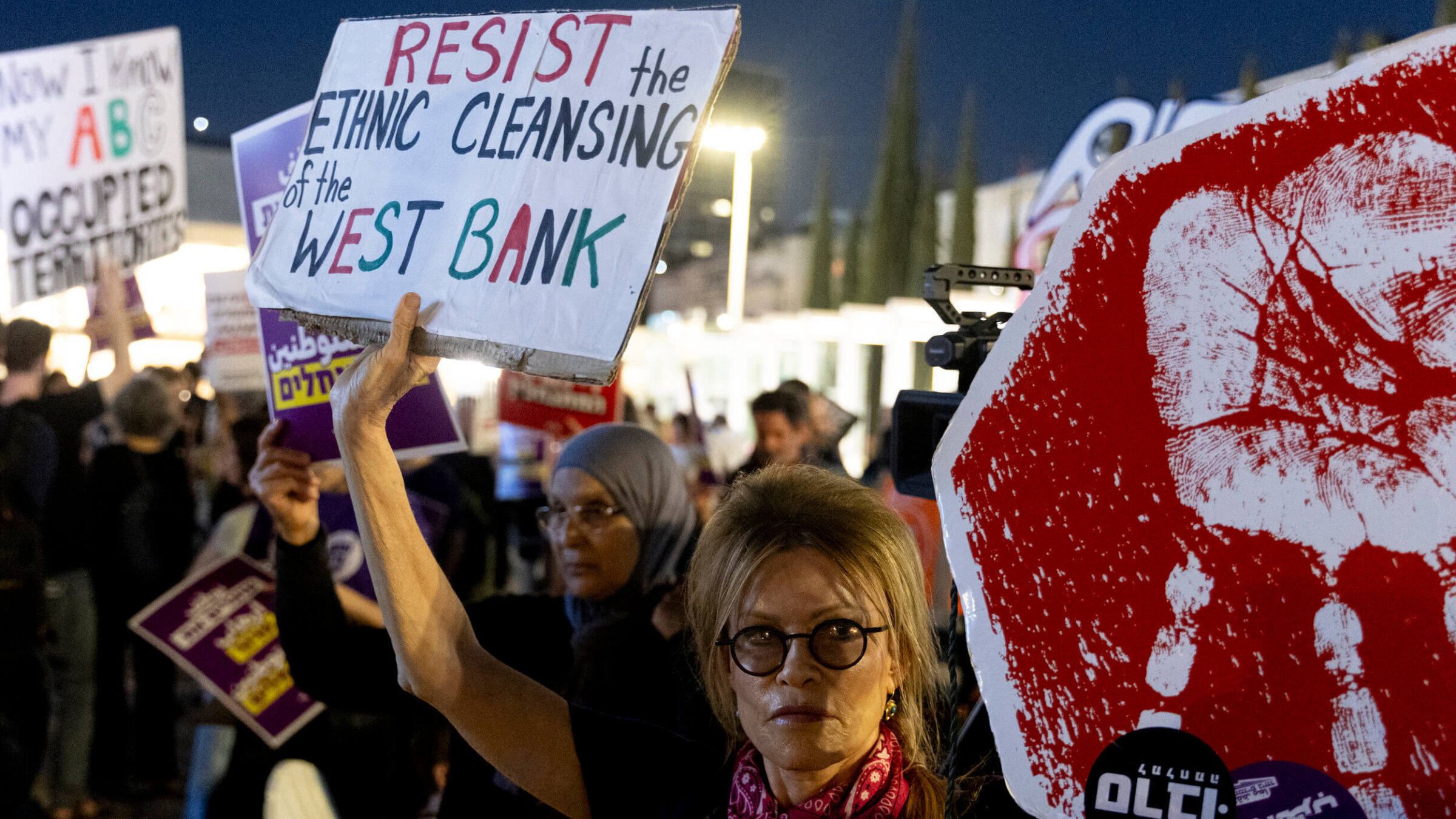 Protesters hold signs during a Tel Aviv rally against settler violence in the West Bank on April 16.