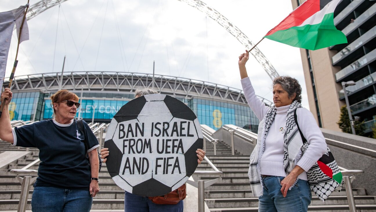 Pro-Palestinian activists protest with a football-shaped sign and a Palestinian flag outside Wembley Stadium to demand that the Football Association issue a public statement calling for the Israeli Football Association (IFA) to be suspended from participation in UEFA and FIFA tournaments on October 2nd, 2025 in London, United Kingdom. 