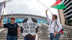 Pro-Palestinian activists protest with a football-shaped sign and a Palestinian flag outside Wembley Stadium to demand that the Football Association issue a public statement calling for the Israeli Football Association (IFA) to be suspended from participation in UEFA and FIFA tournaments on October 2nd, 2025 in London, United Kingdom. 