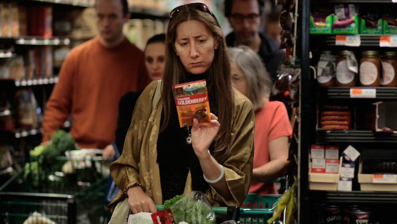 A woman carefully reading the label on a product at the Coop.