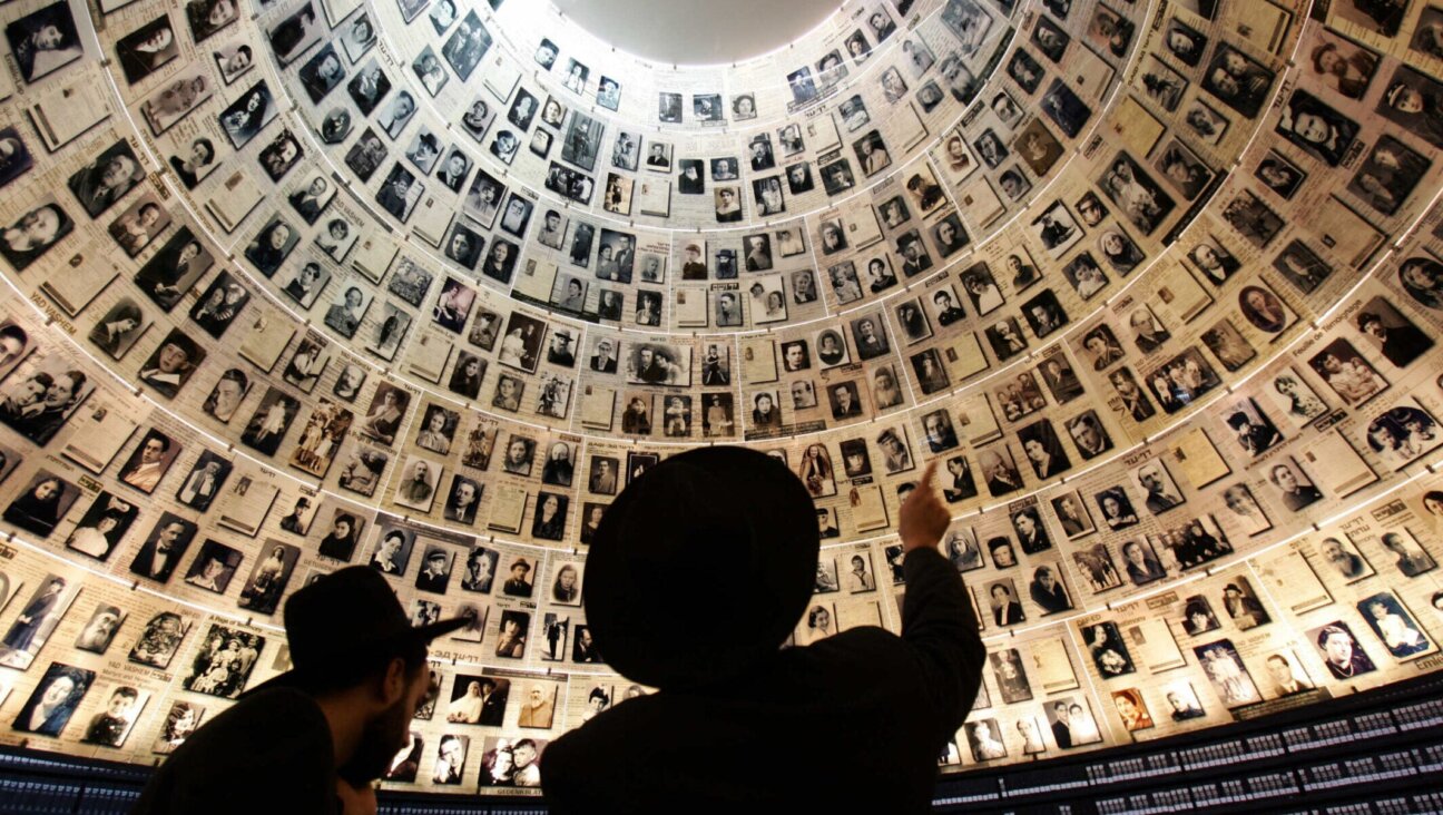 Jews look at the hundreds of photo portraits of Jews who were killed during the Nazi Holocaust in the Hall of Names inside Yad Vashem in Jerusalem, Nov. 1, 2005. (Menaham Kahana / AFP via Getty Images)