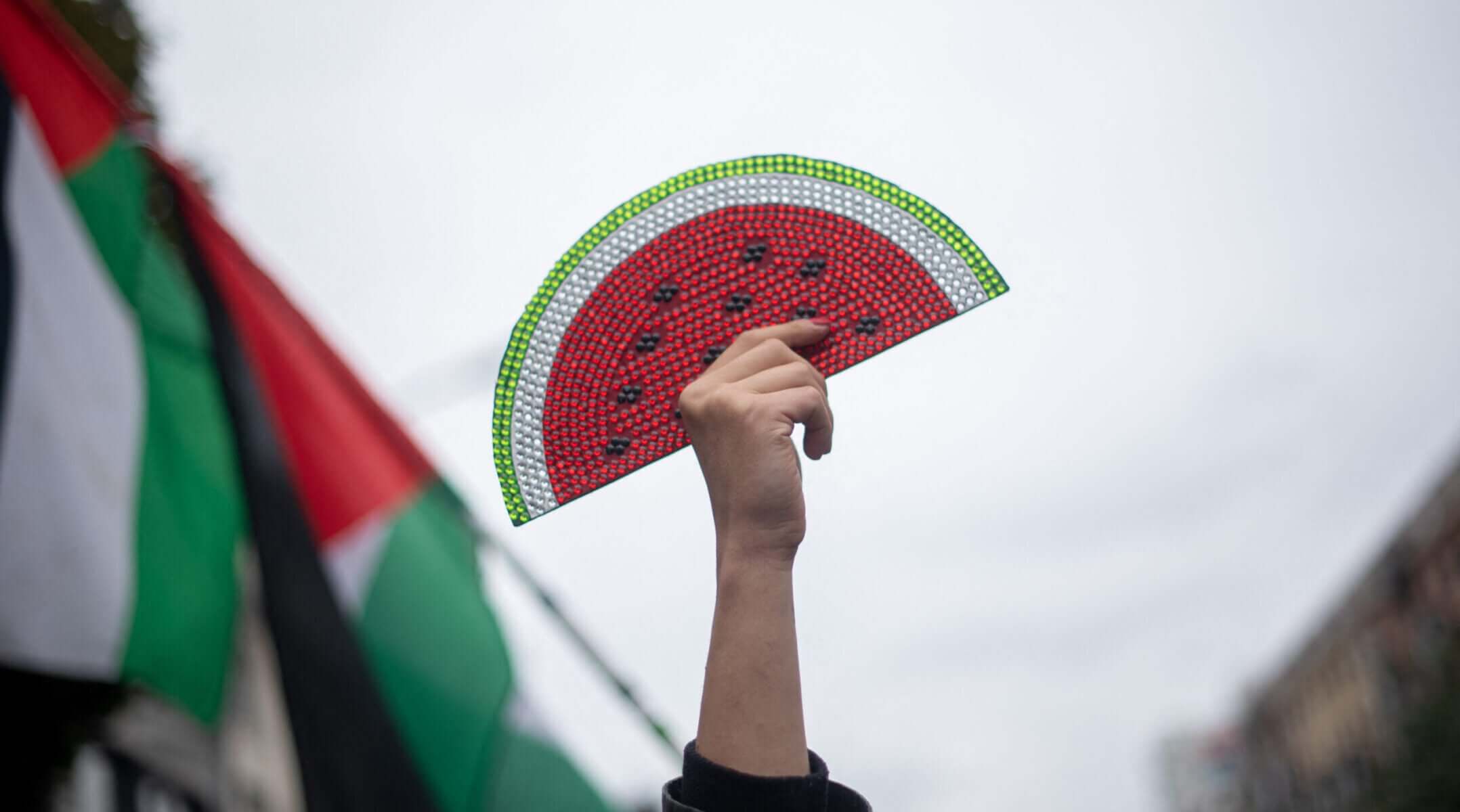 A protester holds a watermelon sign at a rally supporting Palestinians in Gaza, in Berlin, Oct. 6, 2024. (Babak Bordbar / Middle East Images / Middle East Images / AFP via Getty Images)