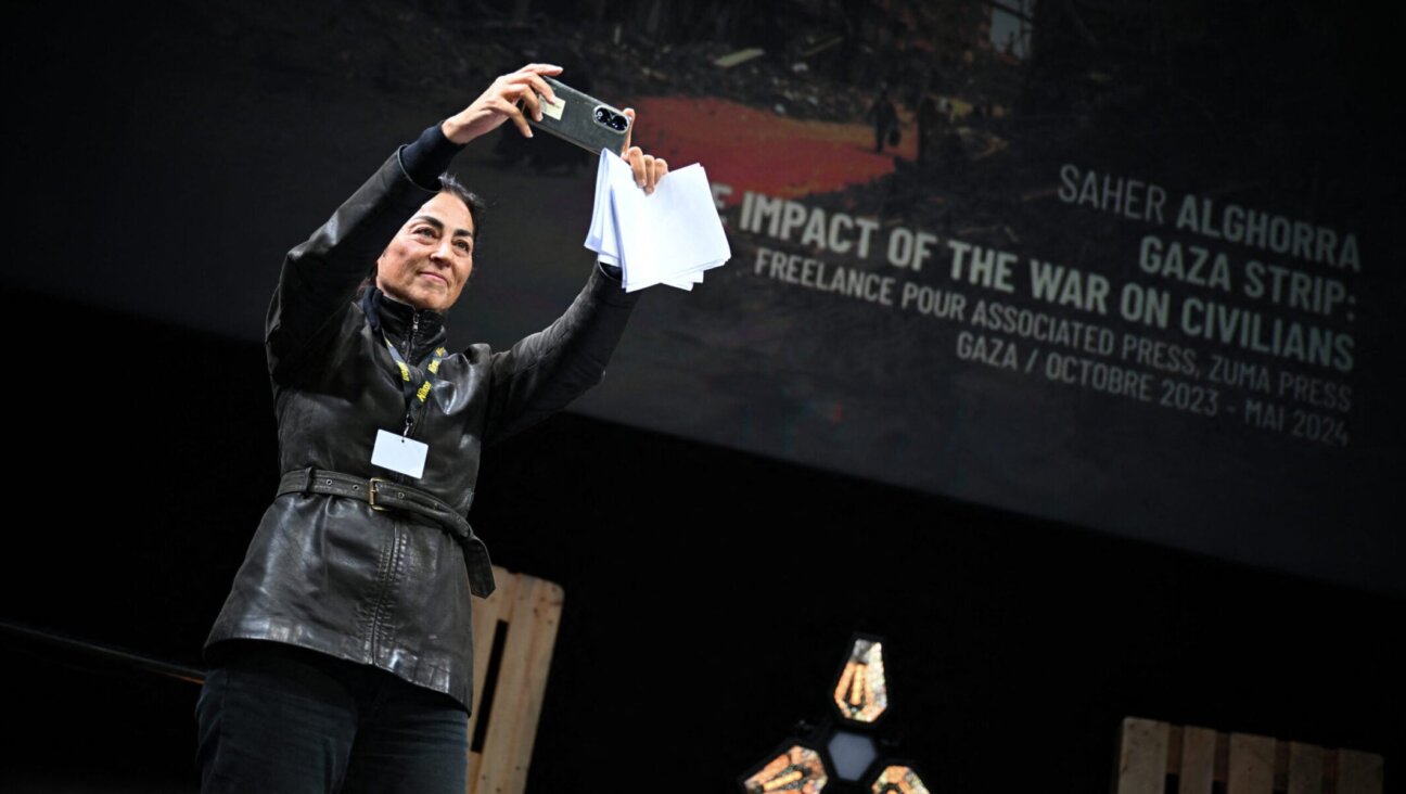 A representative of the Palestinian photographer Saher Alghorra takes a picture as Alghorra receives the 'Young Reporter Trophy' during the 2024 Prix Bayeux Calvados-Normandie in France, Oct. 12, 2024.