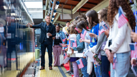 Students gather to welcome one of the events in the nation's celebration of it's 250th birthday, a "freedom 250" train.