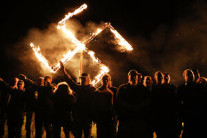Members  of the National Socialist Movement, one of the largest neo-Nazi groups in the US, hold a swastika burning after a rally on April 21, 2018 in Draketown, Georgia.