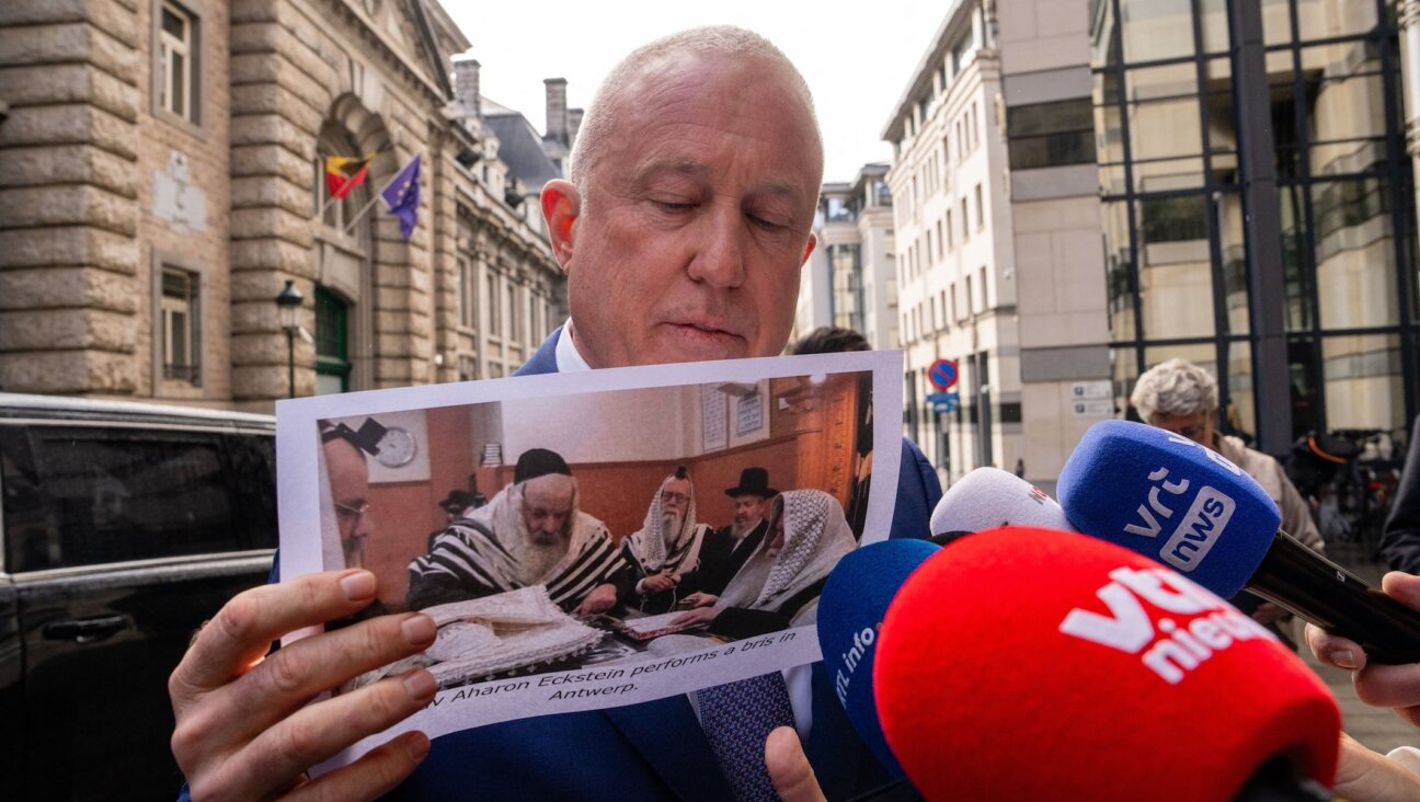 U.S. ambassador to Belgium Bill White shows an image of a ritual circumcision, as he arrives for a meeting at the offices of the Foreign Affairs department of the Federal Government in Brussels on Feb. 17, 2026.