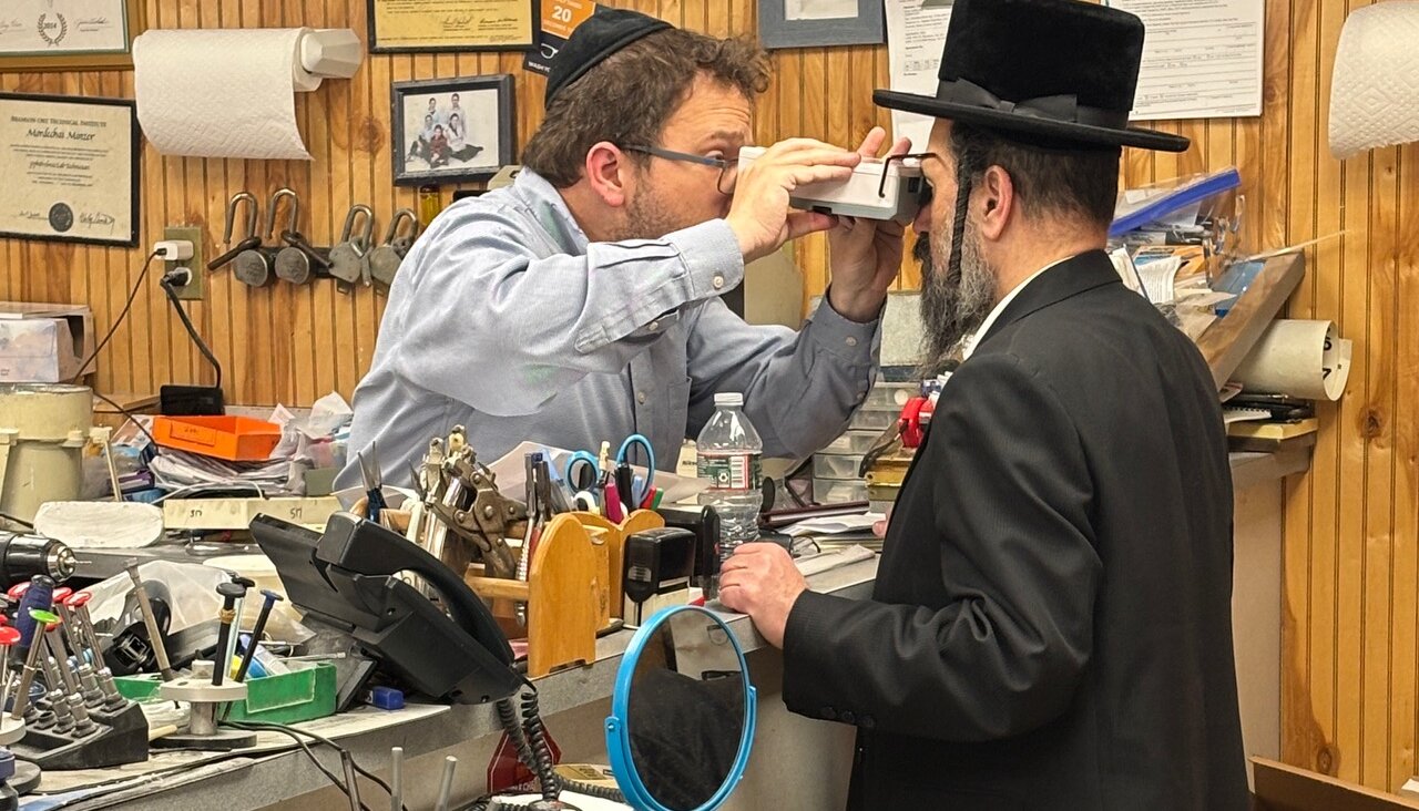 A Minzner employee uses a pupilometer to examine a customer.