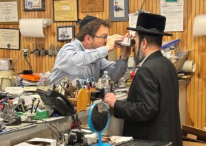 A Minzner employee uses a pupilometer to examine a customer.