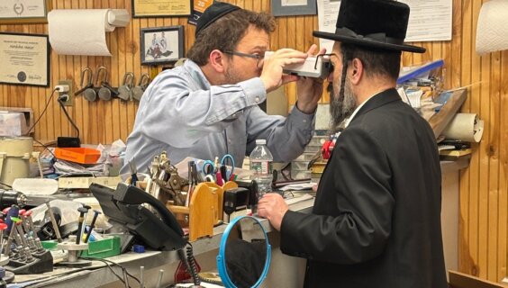 A Minzner employee uses a pupilometer to examine a customer.