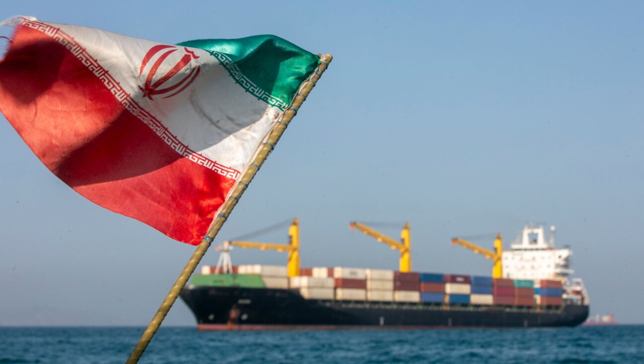 An Iranian flag flutters in the wind as ships remain anchored on May 16, 2026 in the Strait of Hormuz.