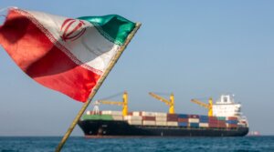An Iranian flag flutters in the wind as ships remain anchored on May 16, 2026 in the Strait of Hormuz.