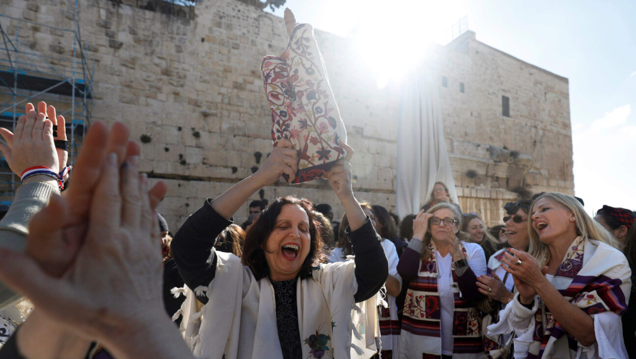 A member of the liberal Jewish religious movement "Women of the Wall" dances with a Torah scroll during an event marking the organization's 30th anniversary on March 8, 2019.