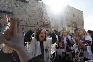 A member of the liberal Jewish religious movement "Women of the Wall" dances with a Torah scroll during an event marking the organization's 30th anniversary on March 8, 2019.