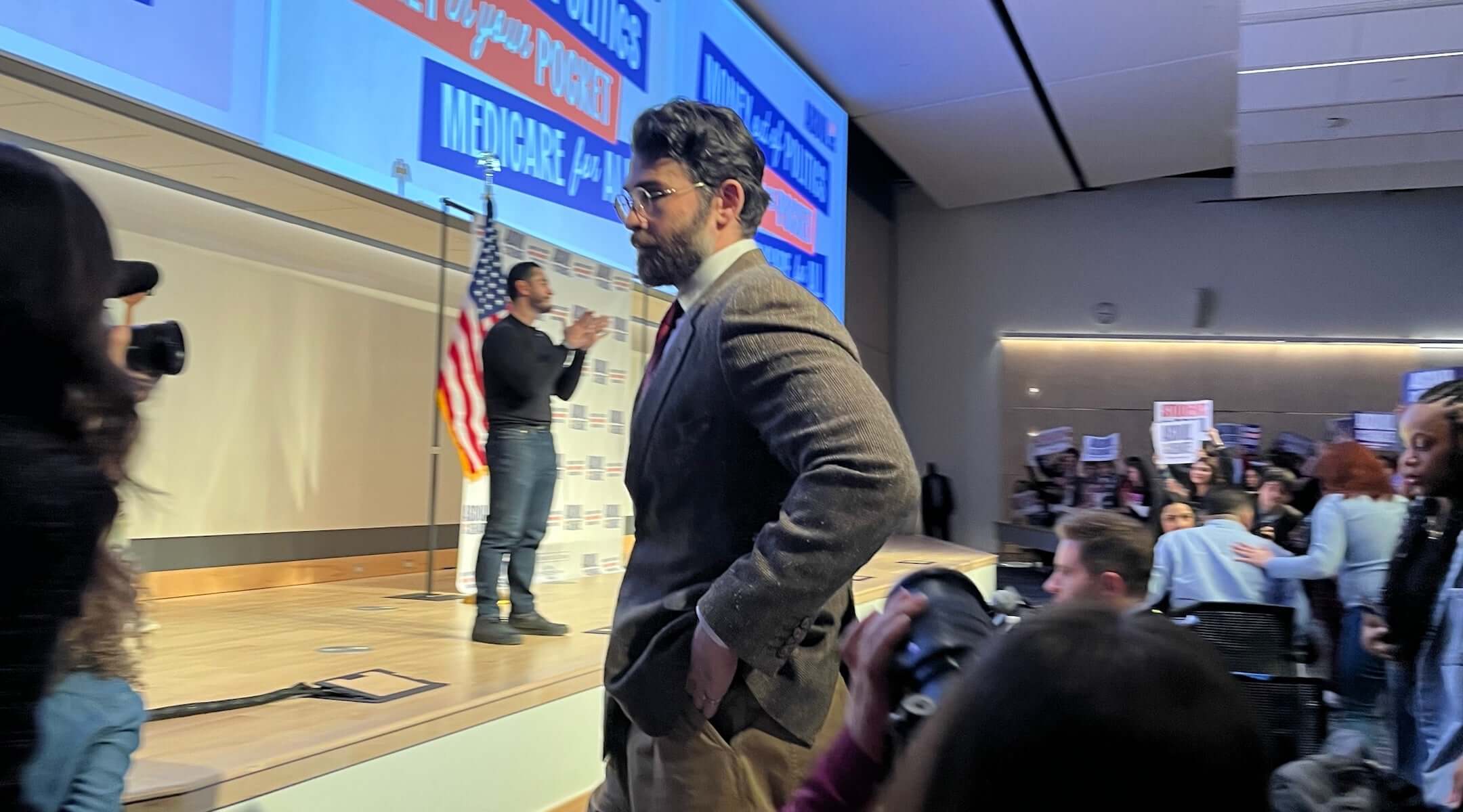 Hasan Piker looks on as U.S. Senate candidate Abdul El-Sayed delivers a stump speech in Ann Arbor, Michigan, April 7, 2026. Piker, a popular Twitch streamer accused of antisemitism, prompted controversy for campaigning with El-Sayed. (Andrew Lapin/JTA)