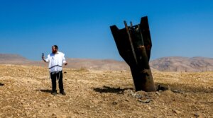 An Israeli man takes a selfie with the wreckage of an intercepted Iranian missile that landed near the West Bank city of Jericho.