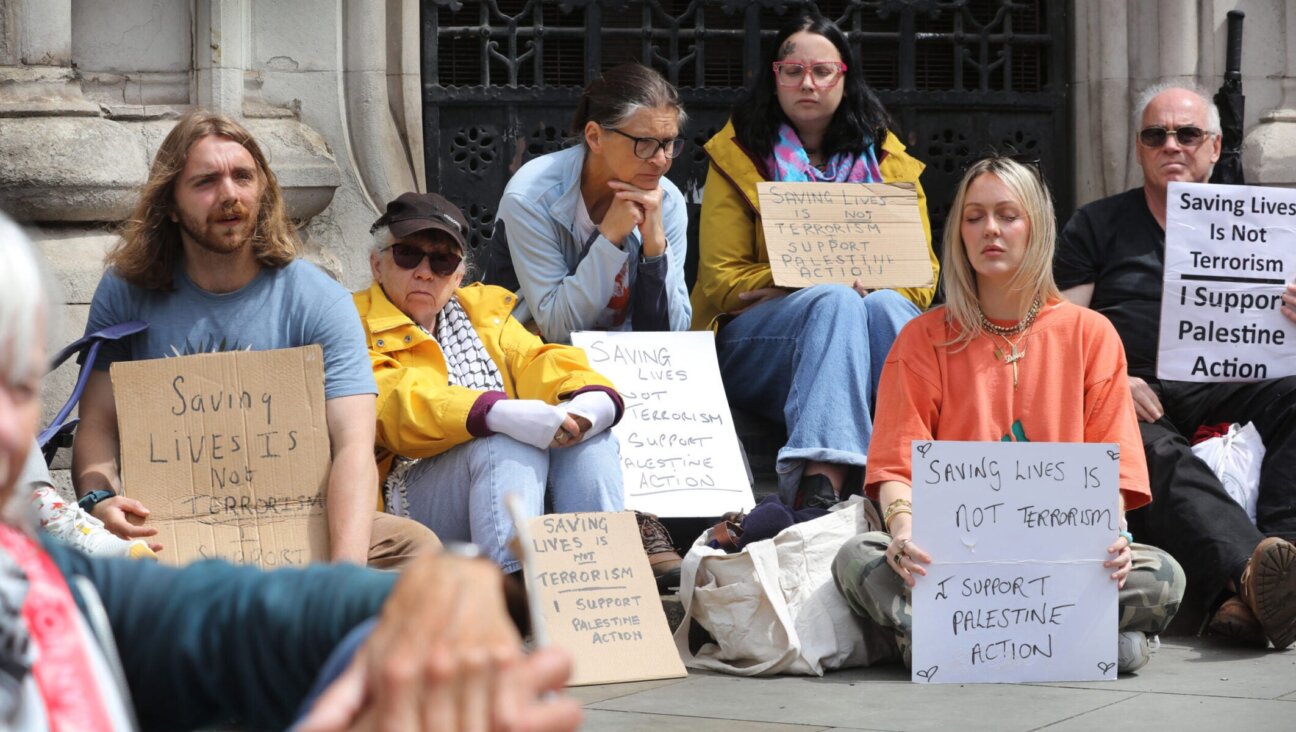 Activists hold signs expressing support for Palestine Action outside a London court where judges upheld a ban on the group, June 15, 2026.