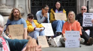 Activists hold signs expressing support for Palestine Action outside a London court where judges upheld a ban on the group, June 15, 2026.