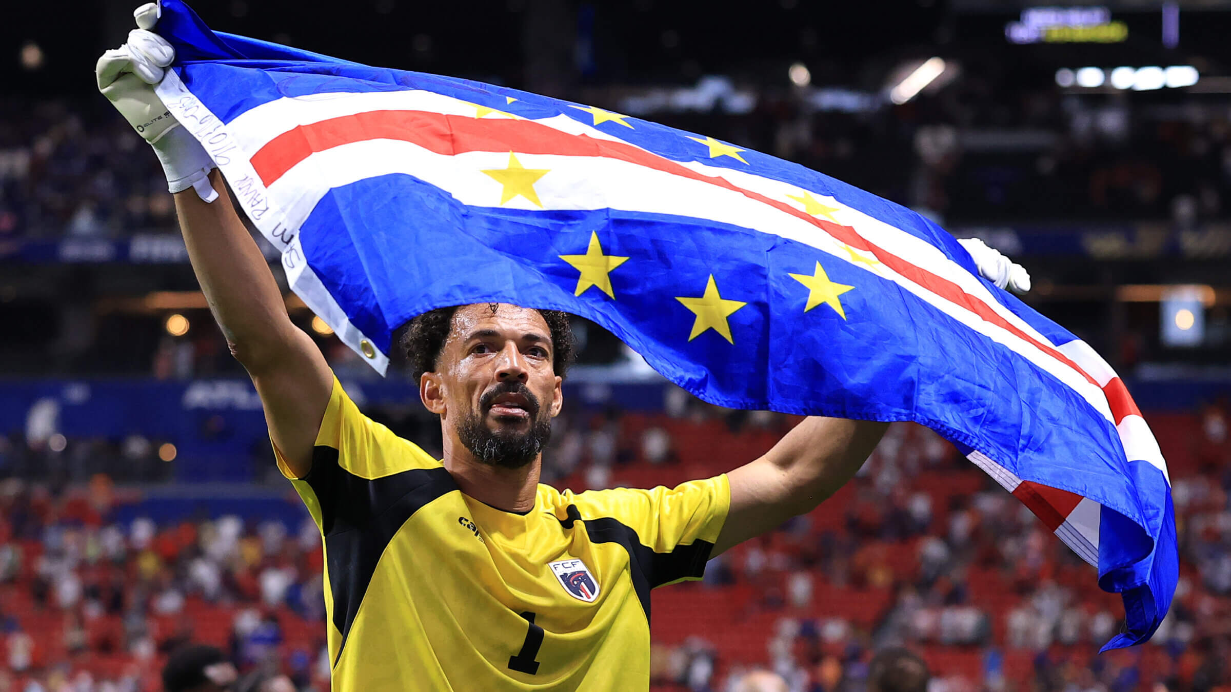 Vozinha, the Cape Verde goalkeeper, waves the national flag after the 0-0 draw with Spain.