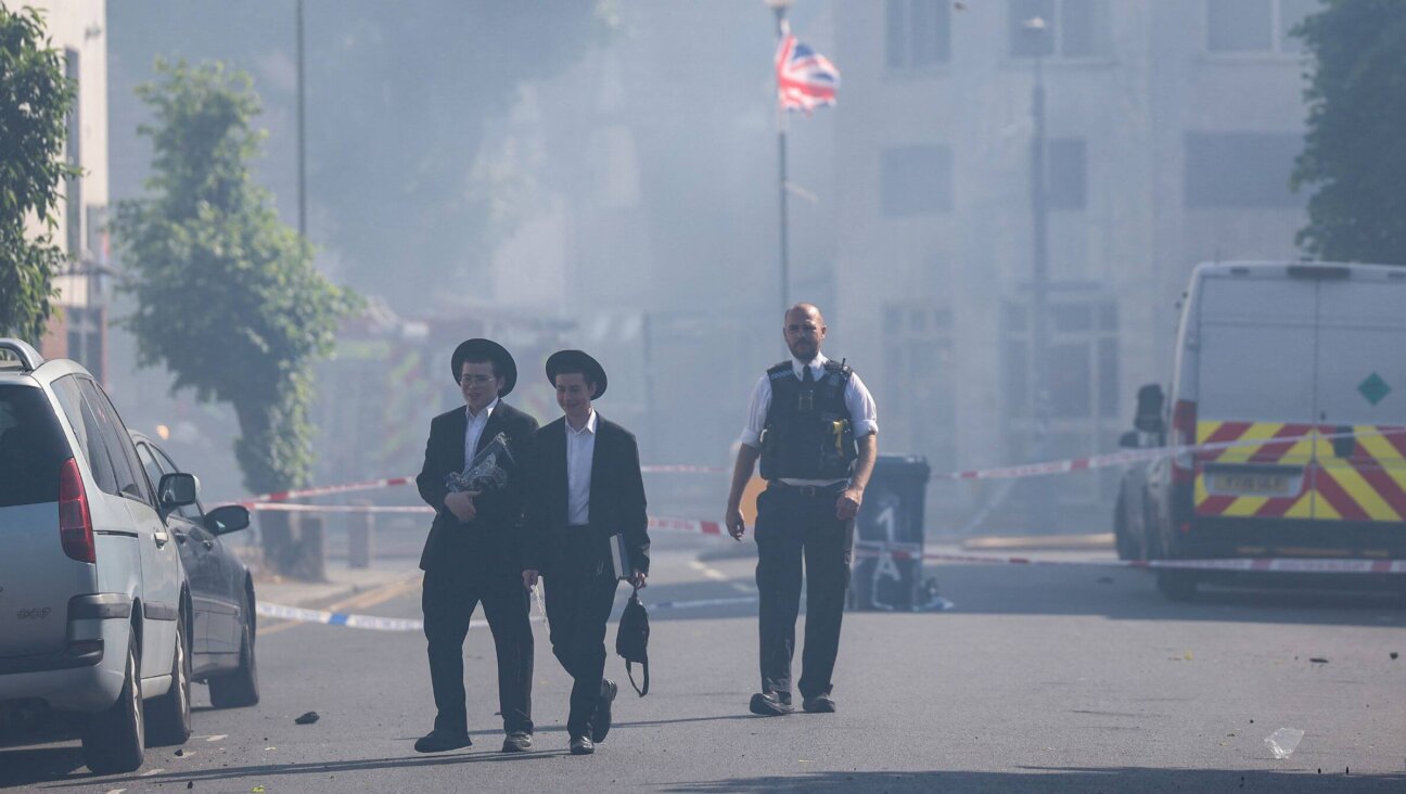 Local residents walk past a cordoned area where a fire broke out at a supermarket in the Golders Green neighbourhood in north London on May 27, 2026. London's firefighting service said on May 27 it was responding to a fire in Golders Green, a north London neighbourhood home to a large Jewish community targeted in recent months by a number of arson attacks. 
