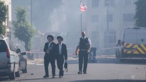 Local residents walk past a cordoned area where a fire broke out at a supermarket in the Golders Green neighbourhood in north London on May 27, 2026. London's firefighting service said on May 27 it was responding to a fire in Golders Green, a north London neighbourhood home to a large Jewish community targeted in recent months by a number of arson attacks. 