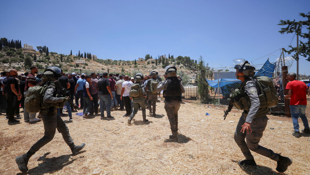 Israeli soldiers move toward a crowd of Palestinian men in a field near the village of Idhna, west of Hebron in the occupied West Bank, on June 5.