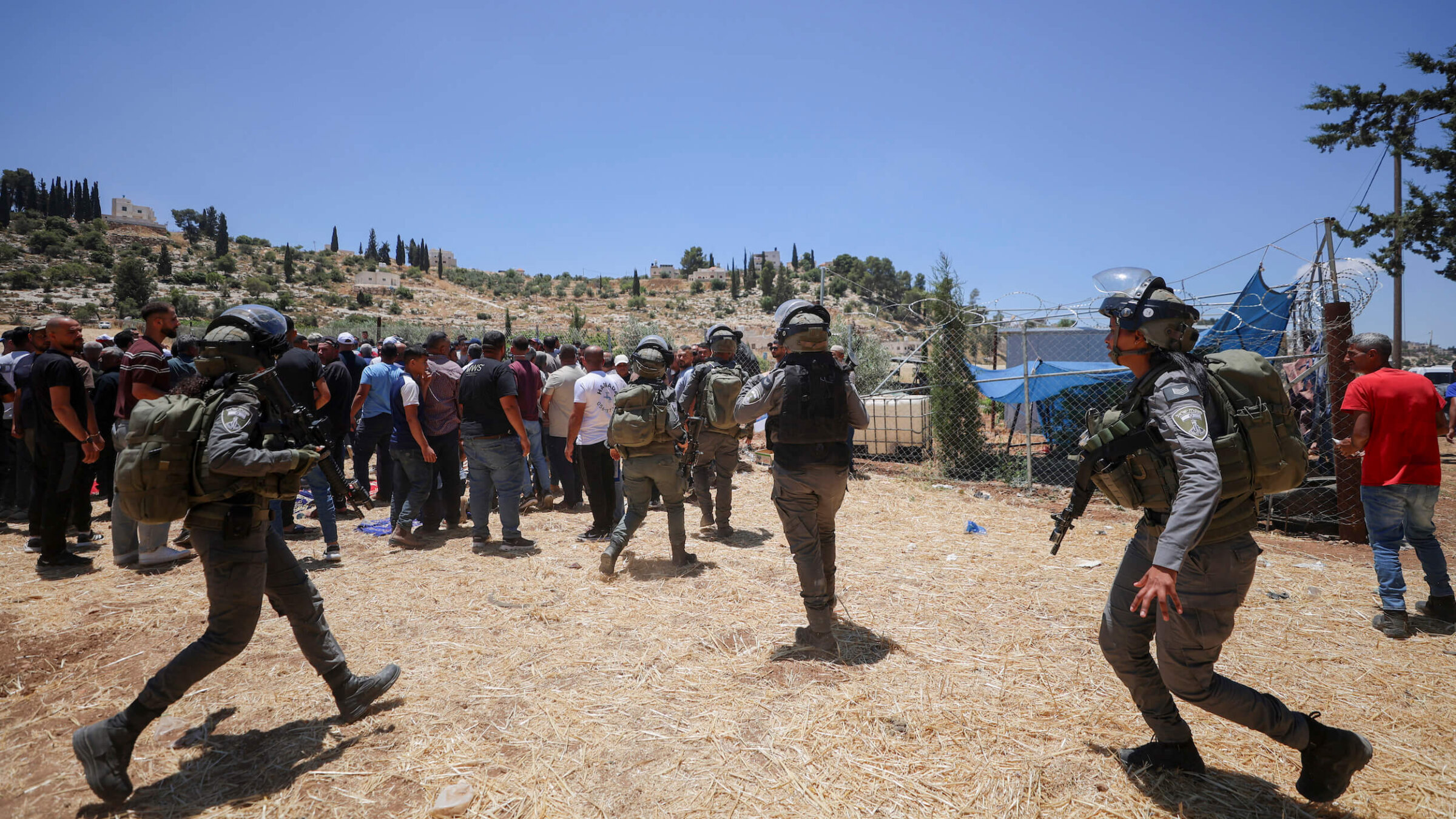 Israeli soldiers move toward a crowd of Palestinian men in a field near the village of Idhna, west of Hebron in the occupied West Bank, on June 5.