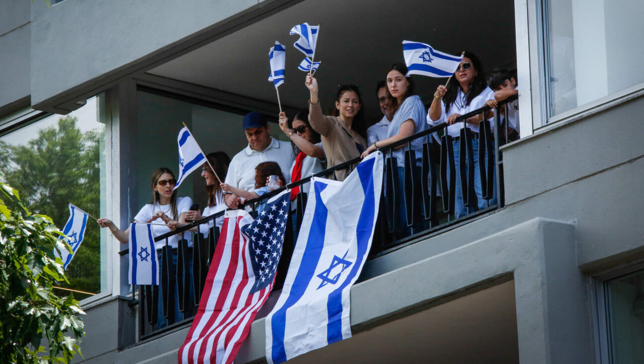 People wave Israeli and United States flags from a balcony on Manhattan's Fifth Avenue as they watch the Israel Day Parade on May 31.