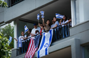 People wave Israeli and United States flags from a balcony on Manhattan's Fifth Avenue as they watch the Israel Day Parade on May 31.